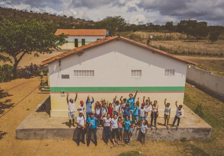 Pessoas se reunem na frente de escola 