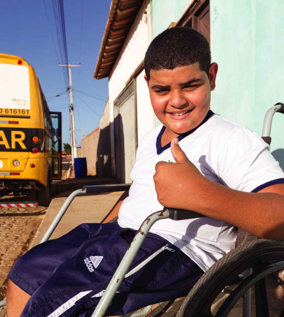 Niltomar, 11 anos, sentado em sua cadeira aguardando o transporte escolar.