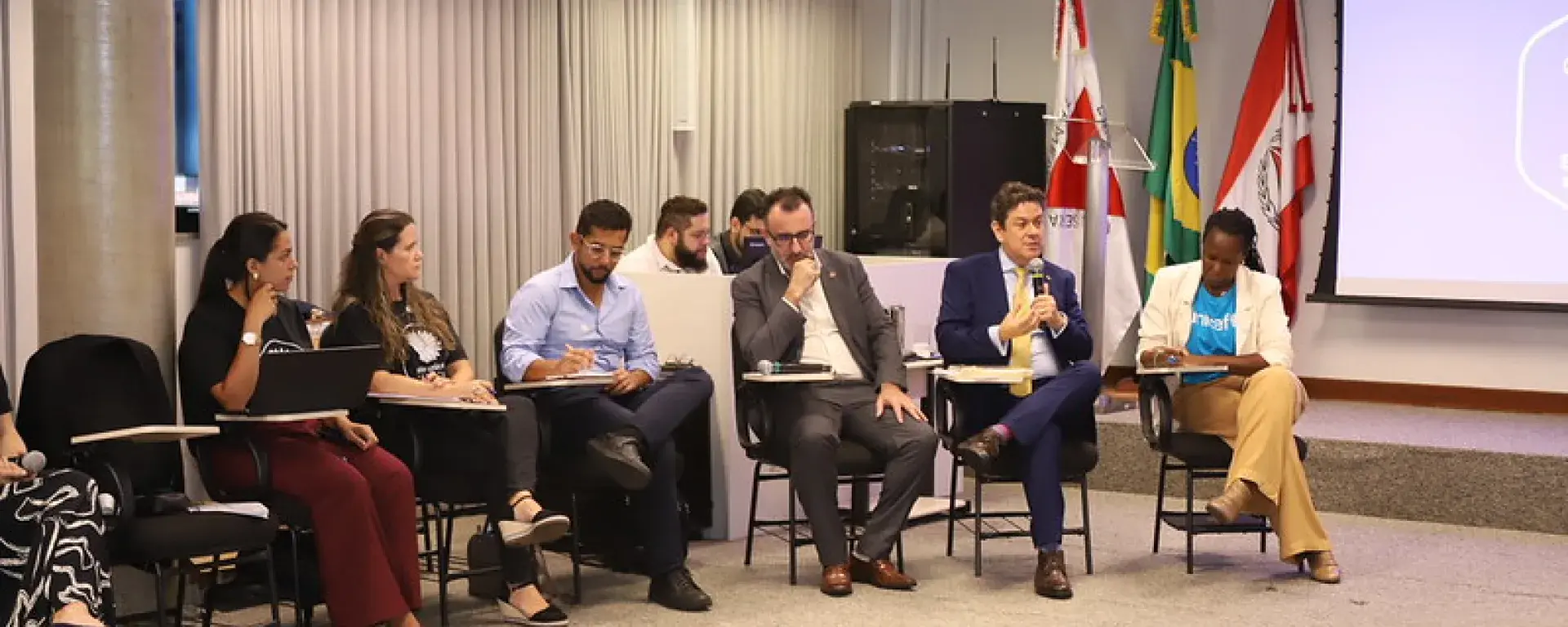 participante segura o microfone durante fala na reunião