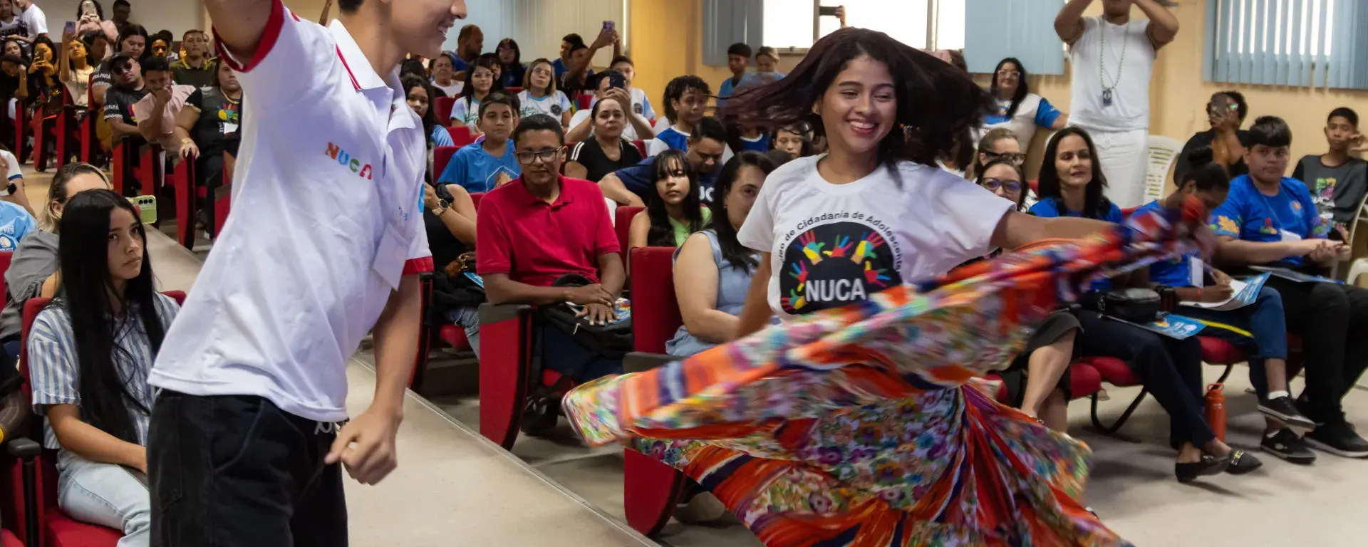 Dois adolescentes dançando carimbó com roupas tradicionais