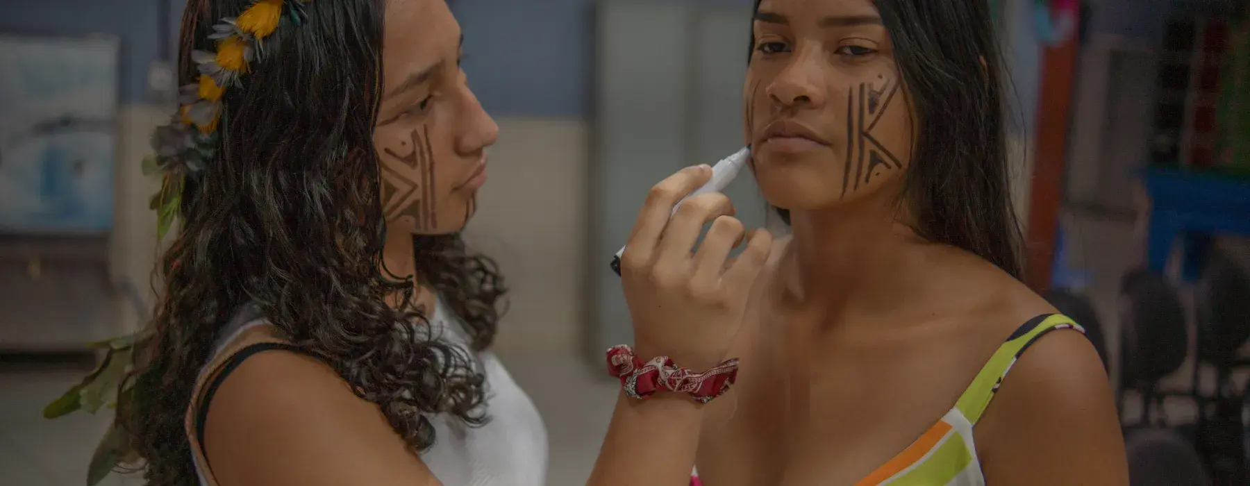 duas meninas indígenas fazem pintura no rosto
