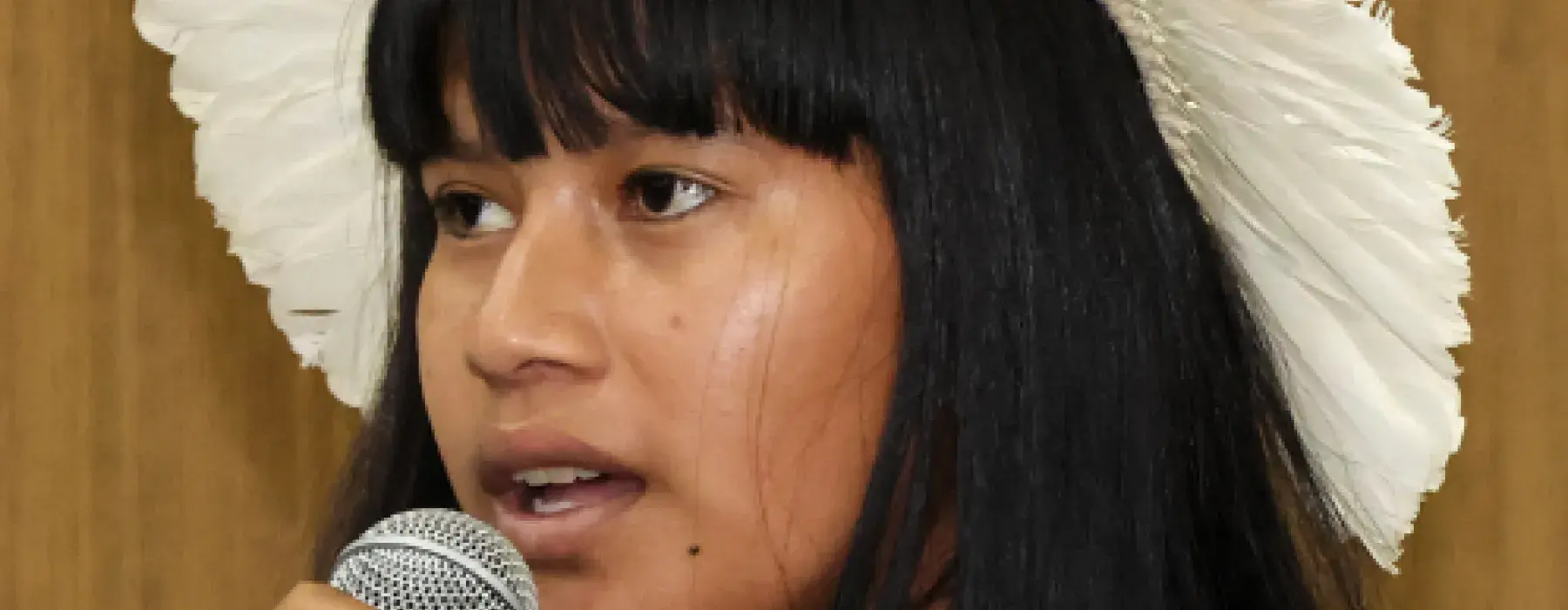 menina indigena segura o microfone e discursa durante a formação sobre equidade