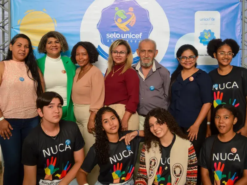 Grupo de pessoas e adolescentes na cerimônia de entrega do Selo UNICEF em Rondônia