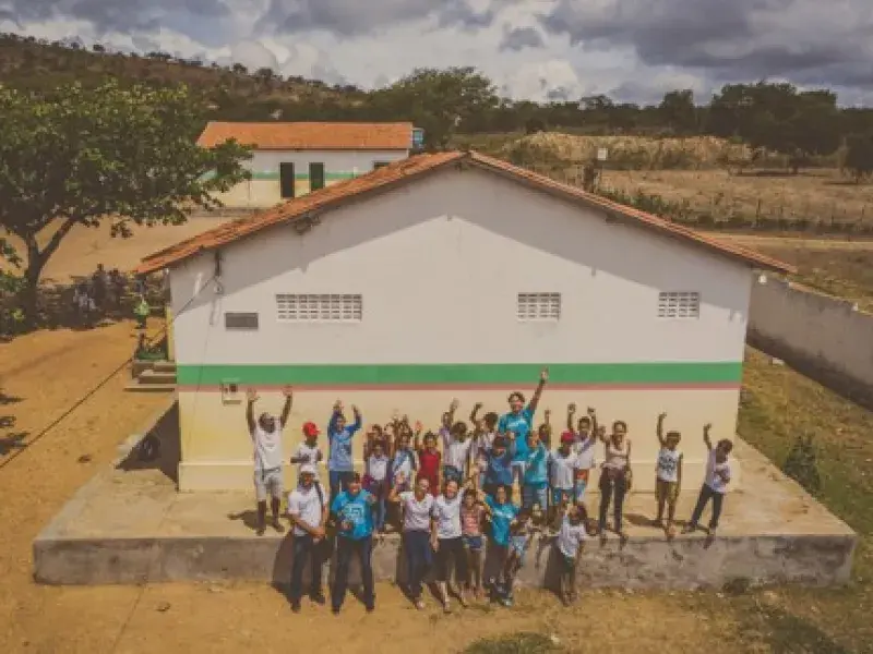 Pessoas se reunem na frente de escola 