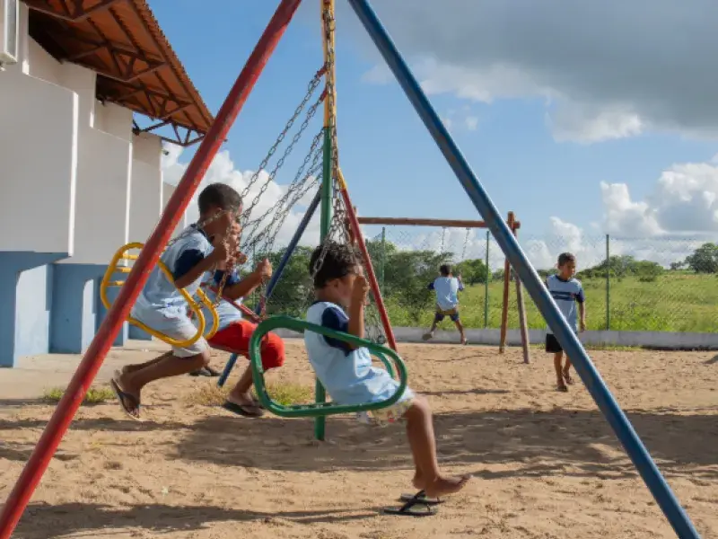 crianças brincam em um balanço ao ar livre