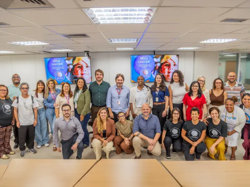 Grupo de representantes de diferentes instituições posa para foto durante encontro do Selo UNICEF em Minas Gerais.