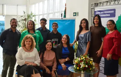 Grupo de pessoas junto com adolescente reunidos para premiação do Selo UNICEF 