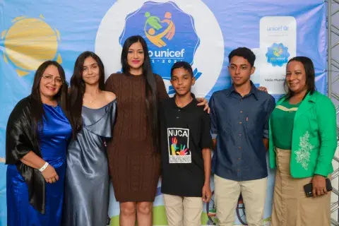 Grupo de pessoas junto com adolescente reunidos para premiação do Selo UNICEF 