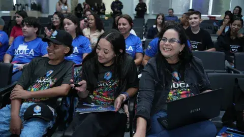 Jovens sentadas em auditório