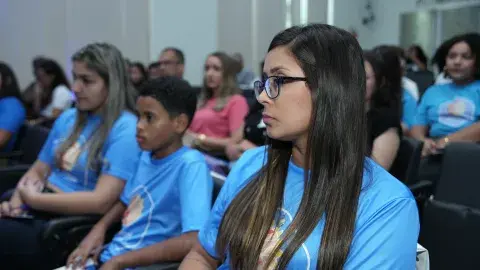 Adolescentes sentados vendo apresentação