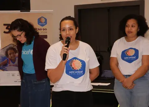 Foto do UNICEF e parceiros falando com microfone