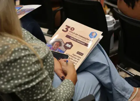 Pessoa segurando pasta com ID Visual do evento