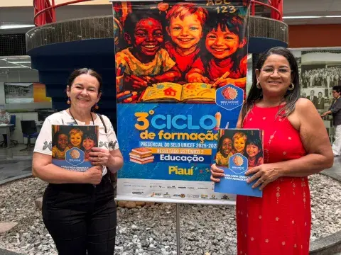 Integrantes do Selo Unicef tiram fotos na frente de banner