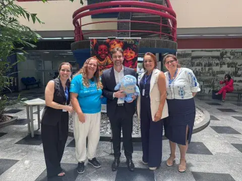 Integrantes do Selo Unicef tiram fotos na frente de banner