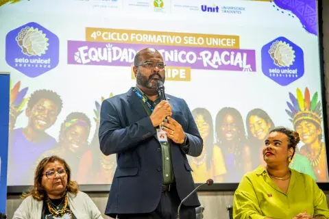 Representante da UNIT fala ao público durante o 4º Ciclo Formativo do Selo UNICEF sobre equidade étnico-racial.