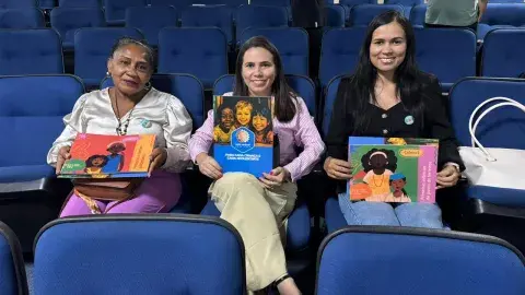 Mobilizadoras e articuladoras municipais segurando os cadernos antirracista do UNICEF