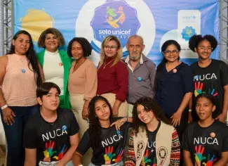 Grupo de pessoas e adolescentes na cerimônia de entrega do Selo UNICEF em Rondônia